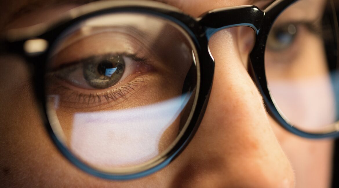 close up of woman eyes in glasses looking at computer screen